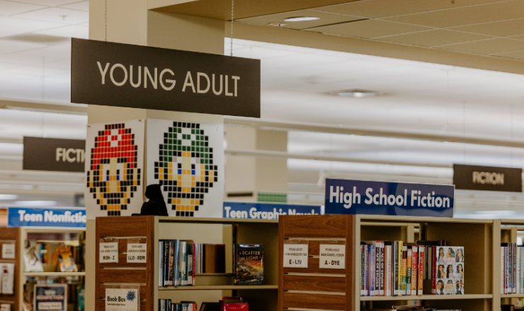 Image of teen section in library with bookshelves and posters of Mario and Luigi on column..